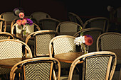 Ein Blumenstrauß inmitten leerer Pariser Bistro-Stühle und Tische; Paris, Frankreich