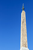 Obelisk mit Statue auf der Spitze und Radierungen auf der Fassade; Rom, Italien