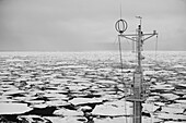 Mast eines Schiffes im mit Treibeis gefüllten Meer; Spitzbergen, Svalbard, Norwegen