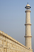 Mann stehend neben dem Taj-Minarett; Agra, Uttar Pradesh, Indien