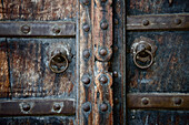 Nahaufnahme einer alten Holztür mit Messingringen; Dharpatha Mal, Madhya Pradesh, Indien