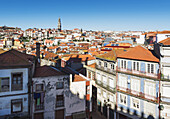 Dächer von Häusern und ein Turm in der Ferne vor blauem Himmel; Porto, Portugal
