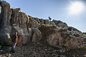 Ein Mann steht und betrachtet eine Schnitzerei in einer zerklüfteten Felswand; Antiochia, Türkei