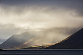 The Sun Shines Through Storm Clouds In The Westfjord Region; Iceland