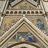 Niedriger Blickwinkel auf die bunt bemalte Fassade des Doms von Orvieto; Orvieto, Umbrien, Italien