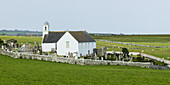 Eine weiße Kirche und ein Friedhof, umgeben von einem Steinzaun; Latheron, Schottland
