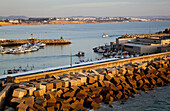Blocks Of Rock Piled Against A Wall In The Harbour, Near Conil De La Frontera; Andalusia, Spain