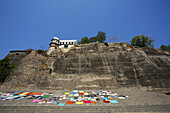 Ahilya Fort und farbenfrohe Wäsche, die an den Ghats des Namada-Flussufers trocknet