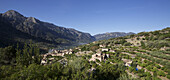 Landscape View Of Hillside Village Backed By Mountains, Mallorca