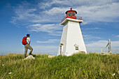 Hiker At Baccaro Point Lighthouse, Bay Of Fundy; Nova Scotia, Canada