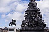 Dekorativer Laternenpfahl mit der Statue von Henri Iv. im Hintergrund; Paris, Frankreich