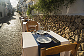 Tische zum Essen entlang einer Straße in der schönen Stadt Altea an der Costa Blanca; Altea, Alicante, Spanien