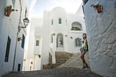 A Chinese Young Woman Standing Against A White Residential Building In Mojacar's Downtown; Mojacar, Almeria, Spain