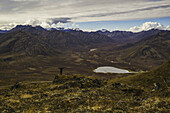 Man Standing On A Look Out Overlooking The Blackstone Valley, Along The Dempster Highway; Yukon, Canada
