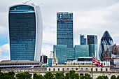 Looking Across The River Thames To The City Of London (The Walkie Talkie Building And The Gherkin) And Union Jack Flag; London, England