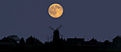 A Glowing Full Harvest Moon Over The Silhouette Of A Skyline Of Buildings; Whitburn, Tyne And Wear, England