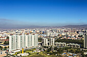 Blick auf Ub City, Mongolei, vom Zaisan-Hügel aus, mit bunten Hochhäusern in der Mitte, umgeben von den Einfamilienhäusern des Ger-Distrikts auf den Hügeln im Hintergrund.  Auch die goldene Buddha-Statue ist zu sehen; Ulaanbaatar, Mongolei