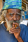 Ein Mann raucht eine Zigarre; Roatan, Bay Islands Department, Honduras