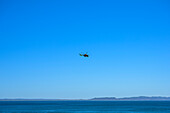 Hubschrauber am blauen Himmel über dem Ozean an der Küste Australiens; Noosa Heads, Queensland, Australien