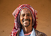 Portrait of an Eritrean man smiling with a headscarf on his head, Monday livestock market; Keren, Anseba Region, Eritrea