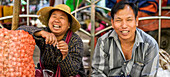 Mann und Frau sitzen lachend auf dem Markt; Taungyii, Shan-Staat, Myanmar