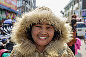 Woman wearing a warm, fur-trimmed coat at the market; Lashio, Shan State, Myanmar