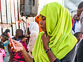 Frau benutzt ihr Smartphone während des muslimischen Festes Mawlid al-Nabi, das an die Geburt des Propheten Mohammed erinnert; Omdurman, Khartum, Sudan
