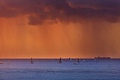 Sailboats in the Pacific Ocean at sunset in a storm off the Island of Oahu; Oahu, Hawaii, United States of America