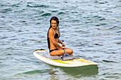 Mädchen sitzt auf einem Stand Up Paddle Board; Maui, Hawaii, Vereinigte Staaten von Amerika