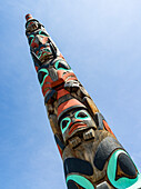 Low angle view of a colourful totem in a blue sky, Jasper National Park, Alberta, Canada