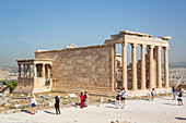 Touristen bei der Besichtigung des Tempels des Erectheion, Akropolis von Athen, archäologische Stätte mit Ruinen; Athen, Griechenland