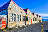 Verwitterte Gebäude entlang einer Straße mit Blick auf die Küstenlinie der Shelly Bay auf der Nordinsel Neuseelands im Bezirk Miramar; Wellington, Nordinsel, Neuseeland