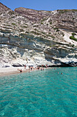 Tourists swimming in the clear, turquoise water of Galazia Nera Bay; Polyaigos Island, Cyclades, Greece