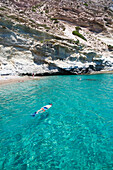 Männlicher Tourist beim Schnorcheln im klaren, türkisfarbenen Wasser der Bucht von Galazia Nera; Insel Polyaigos, Kykladen, Griechenland