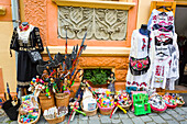Variety of goods for sale on display on a sidewalk outside a shop; Sighisoara, Mures County, Transylvania Region, Romania