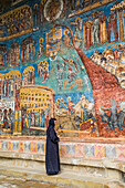 Nun viewing the 'Last Judgement' fresco, Voronet Monastery, 1487; Gura Humorului, Suceava County, Romania