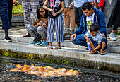 People feeding koi (Cyprinus rubrofuscus) in a pool, Tirta Gangga; Bali, Indonesia