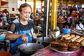 Frau bei der Zubereitung von Süßigkeiten auf dem Tomohon-Markt; Tomohon, Nordsulawesi, Indonesien