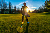 Female golfer backlit by sunlight; Switzerland