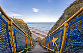 Eine Treppe mit buntem Geländer führt hinunter zum Strand, Marsden Bay; South Shields, Tyne and Wear, England