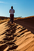 Touristin geht auf eine Sanddüne, Elim-Düne, Namib-Wüste; Sesriem, Namibia