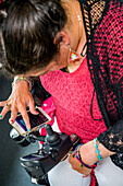 Maori-Frau mit Cerebralparese in einem Rollstuhl, die ein Smartphone benutzt; Wellington, Neuseeland