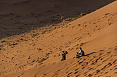 Pärchen beim Fotografieren auf der Düne 45, Sossusvlei, Namib-Wüste, Namib-Naukluft-Nationalpark; Namibia