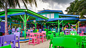 Colourful restaurant and bar with vibrant coloured chairs, tables and decor; Belize