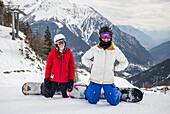 Two girls snowboarding in the Aosta Valley, Italian side of Mont Blanc; Courmayeur, Valle d'Aosta, italy