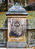 Decorative stone post with floral and nature elements embellishing the front, autumn in Central Park, Manhattan; New York City, New York, United States of America