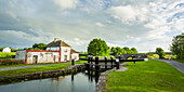 Old red and white house beside a lock on the grand canal in Kildare on a summer evening; Rathangan, County Kildare, Ireland