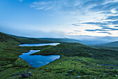 Blick in der Morgendämmerung über zwei Seen in den Galty Mountains; Grafschaft Limerick, Irland