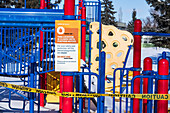 Ein während der Weltpandemie COVID-19 mit Absperrband gesperrter Spielplatz; Edmonton, Alberta, Kanada