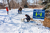 Familien stehen während der Weltpandemie Covid-19 auf einem Weg durch einen Park und besuchen sich aus der Ferne; St. Albert, Alberta, Kanada